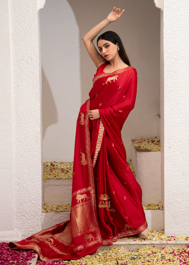 Vantara deep red Banarasi satin silk saree with Shikargah hunting motif in gold zari